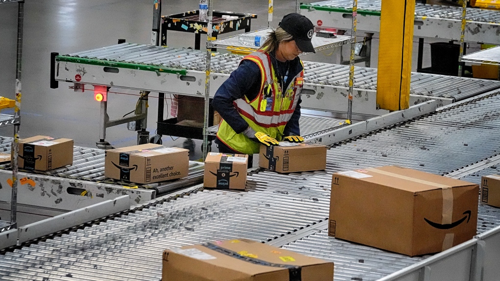 An Amazon employee puts packages on to a conveyor belt at an Amazon delivery station on Tuesday, July 16, 2024, in South Gate, Calif. (AP Photo/Richard Vogel)