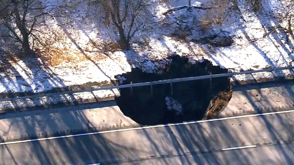 Work crews look on as a sinkhole opened up along Interstate 80 near Wharton, N.J., Dec. 26, 2024. (WABC-TV via AP)